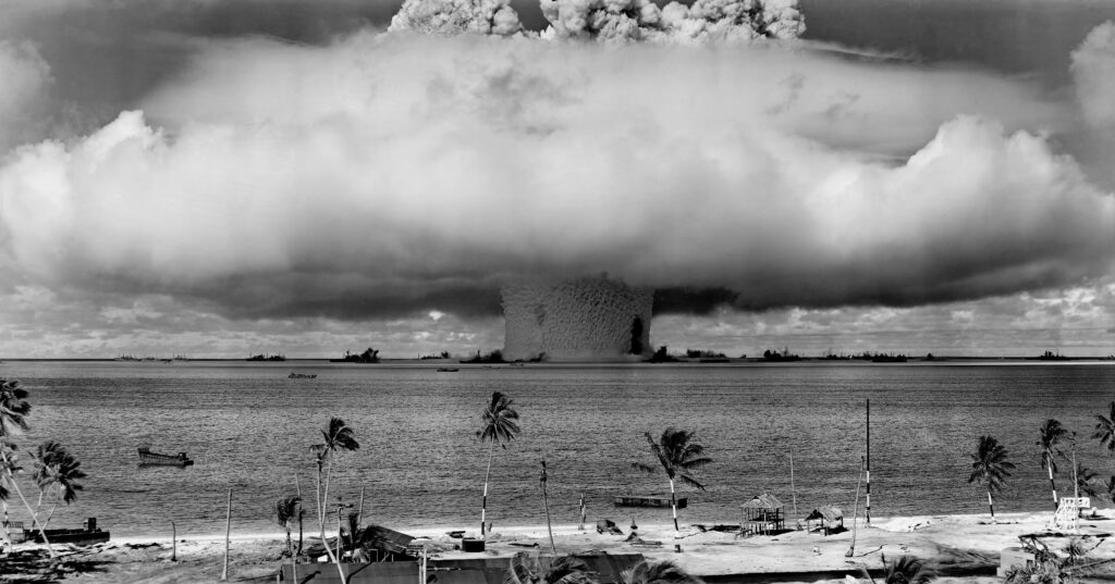 Picture of an atomic bomb on a beach in black and white.